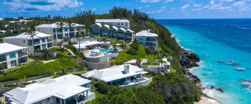 An aerial view of a resort on a large cliff overlooking the ocean.