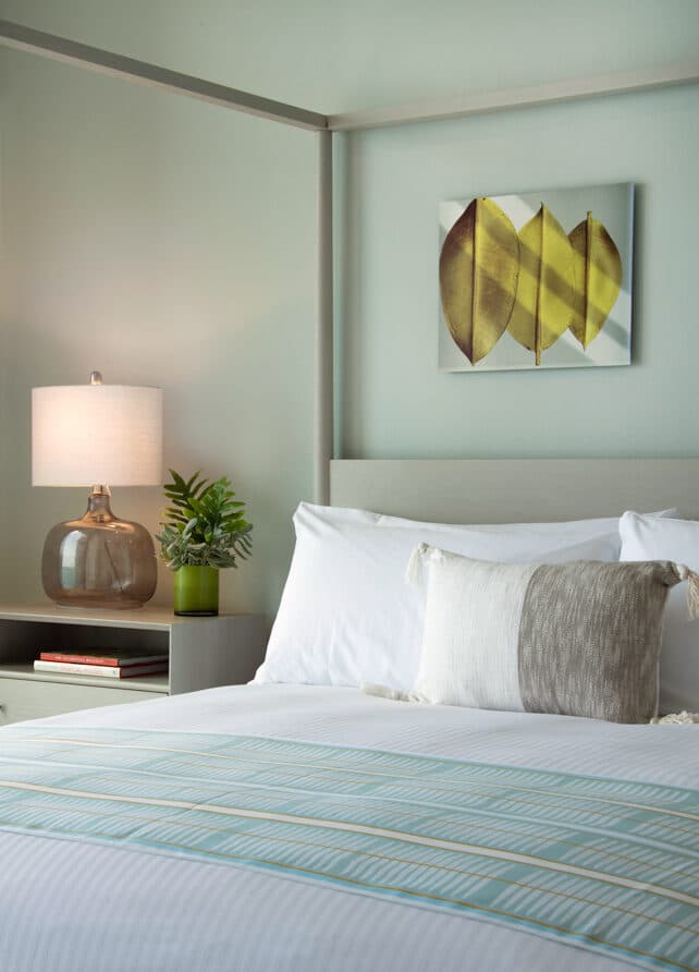 A canopy bed along with a bedside table.