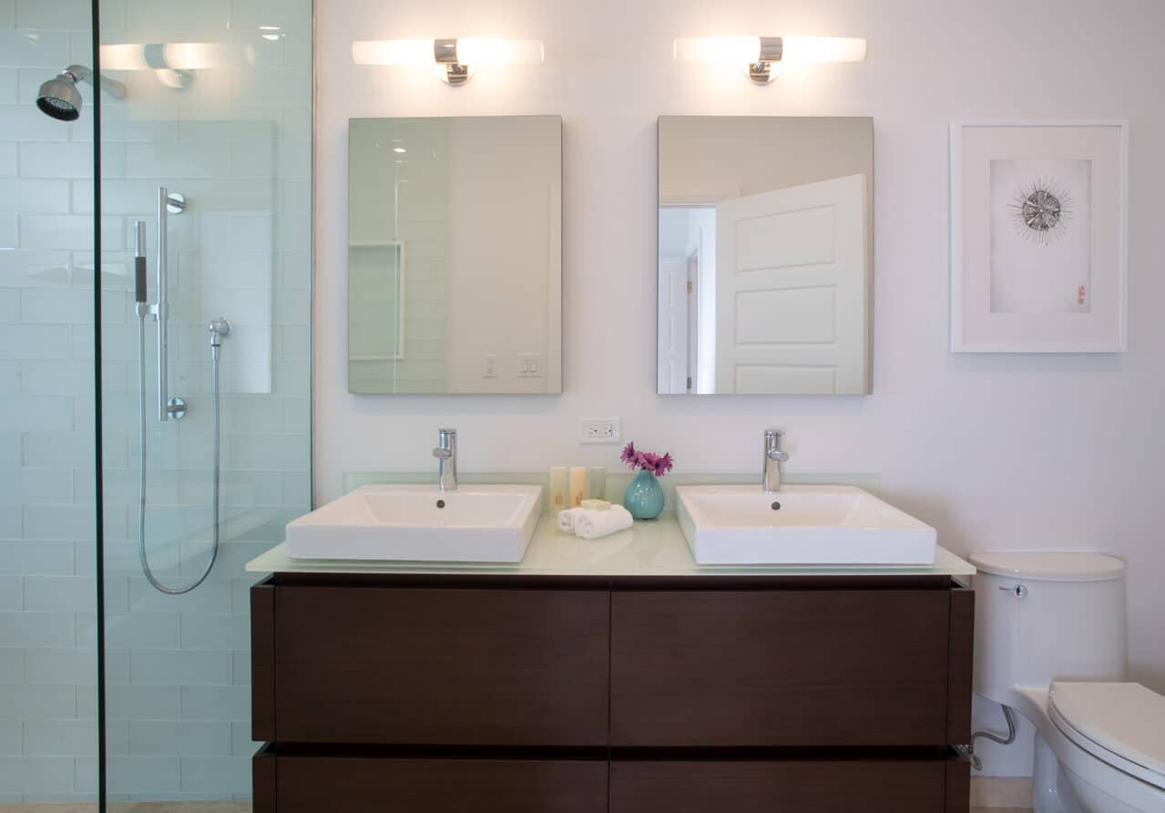 A bathroom with two sinks and two mirrors.