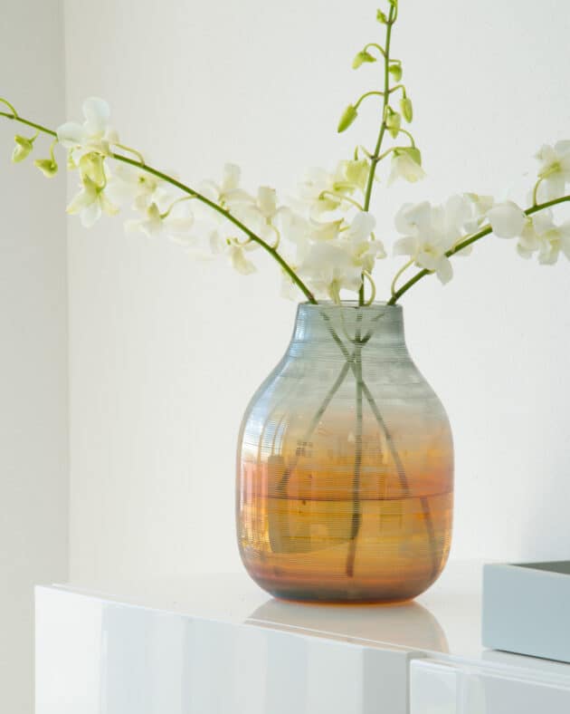 A vase with white orchids.