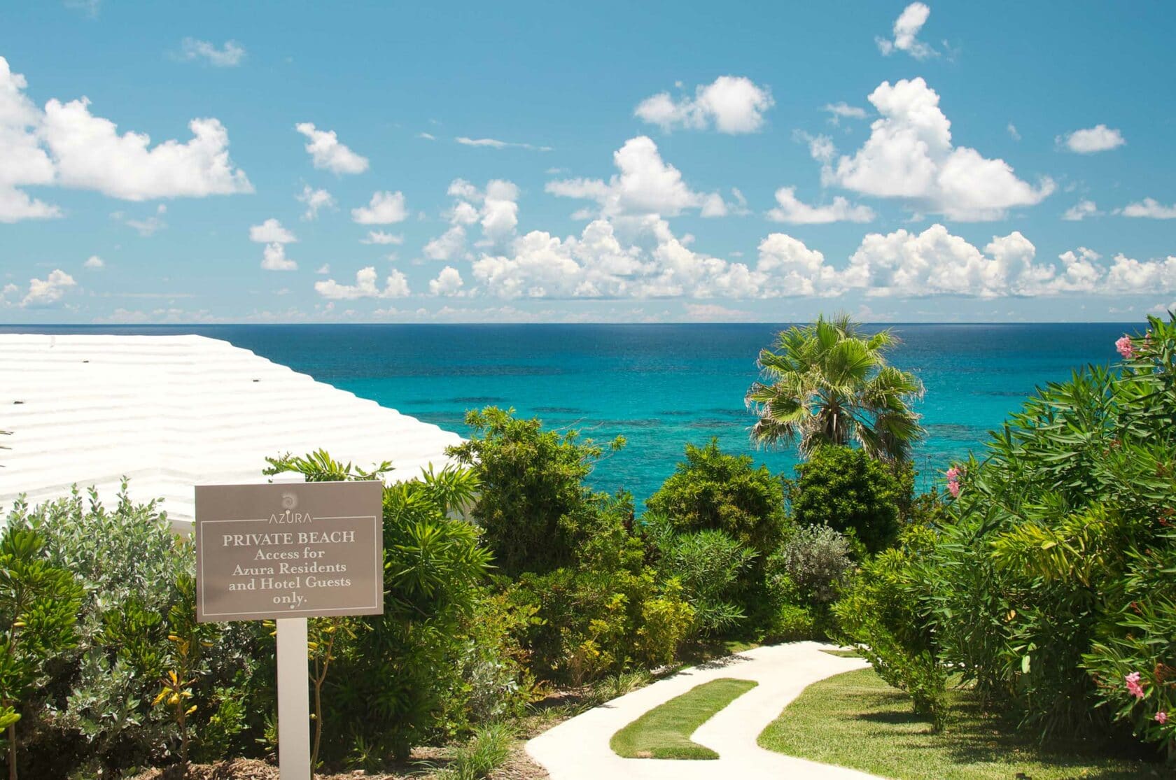 A path leading to a beach with a sign that reads, "Private Beach'.