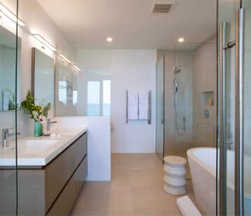 A bathroom with two sinks, a bath tub, and a shower booth.