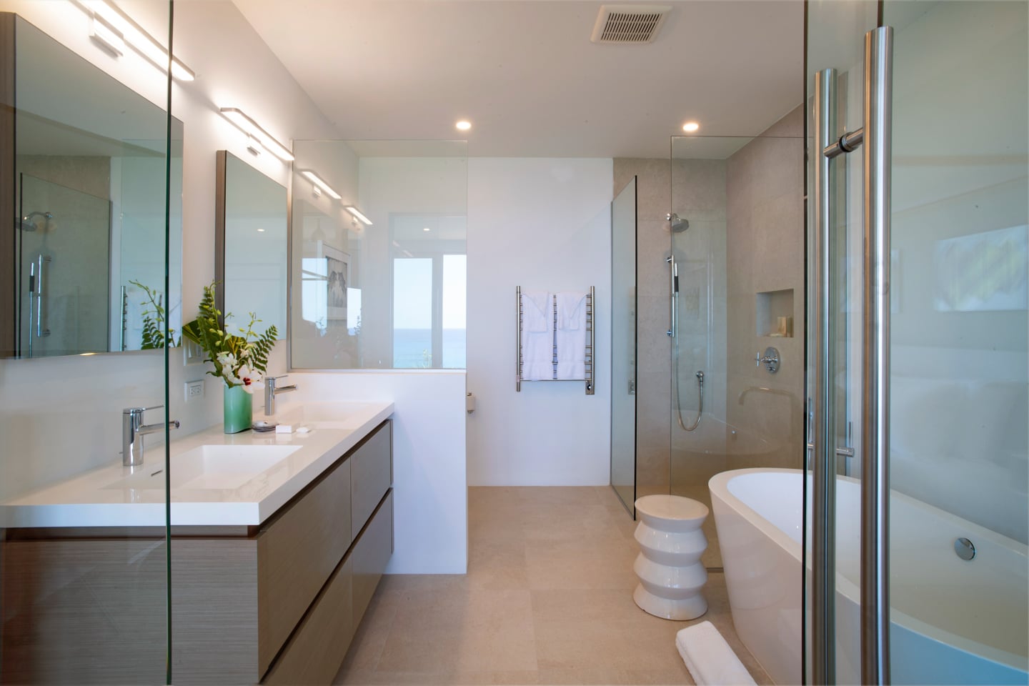 A bathroom with two sinks, a bath tub, and a shower booth.