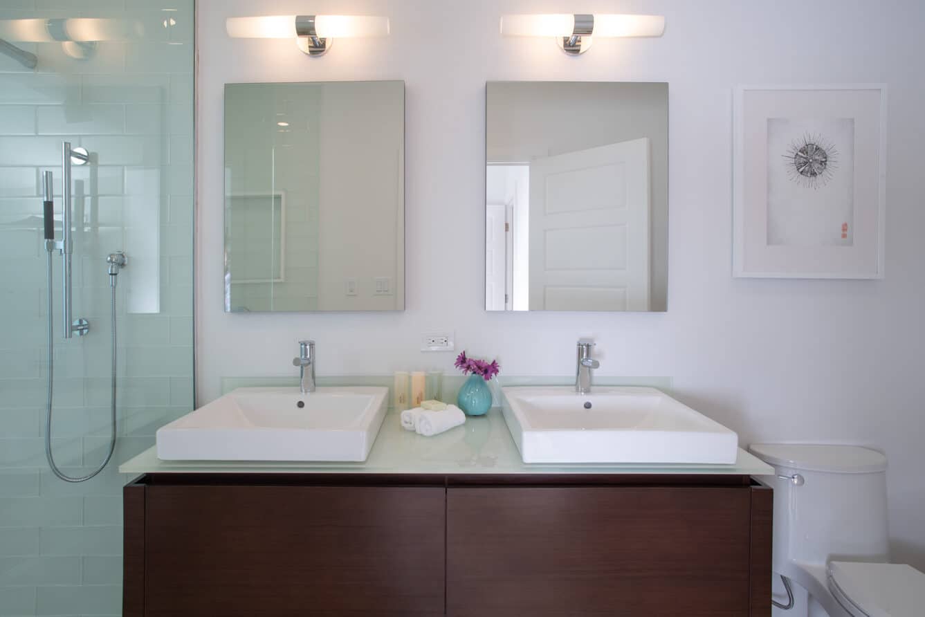 Two bathroom sinks with two mirrors.