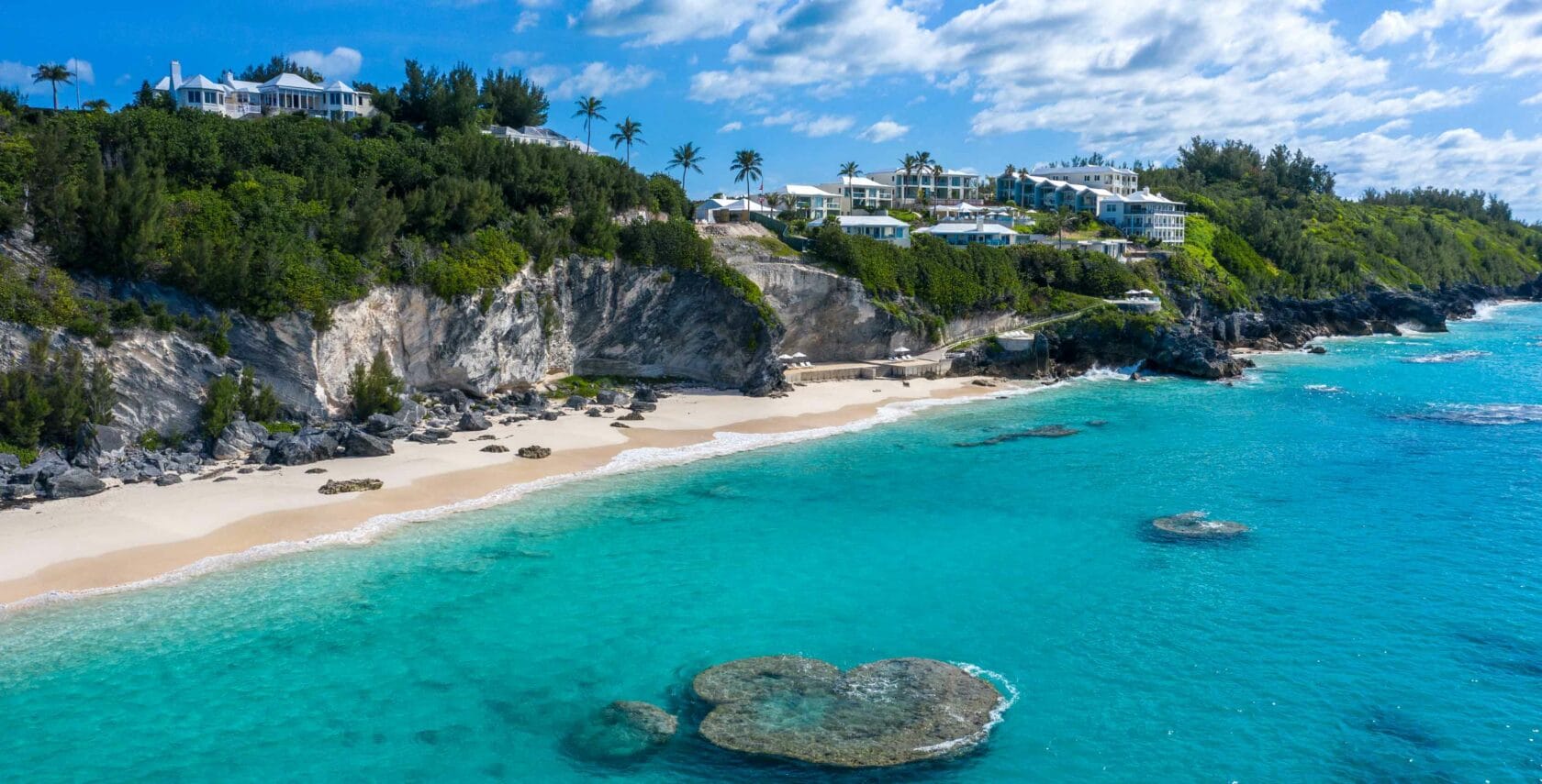 A resort on cliffs overlooking the beach and ocean.