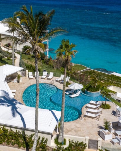 An aerial view of an outdoor pool overlooking the ocean.